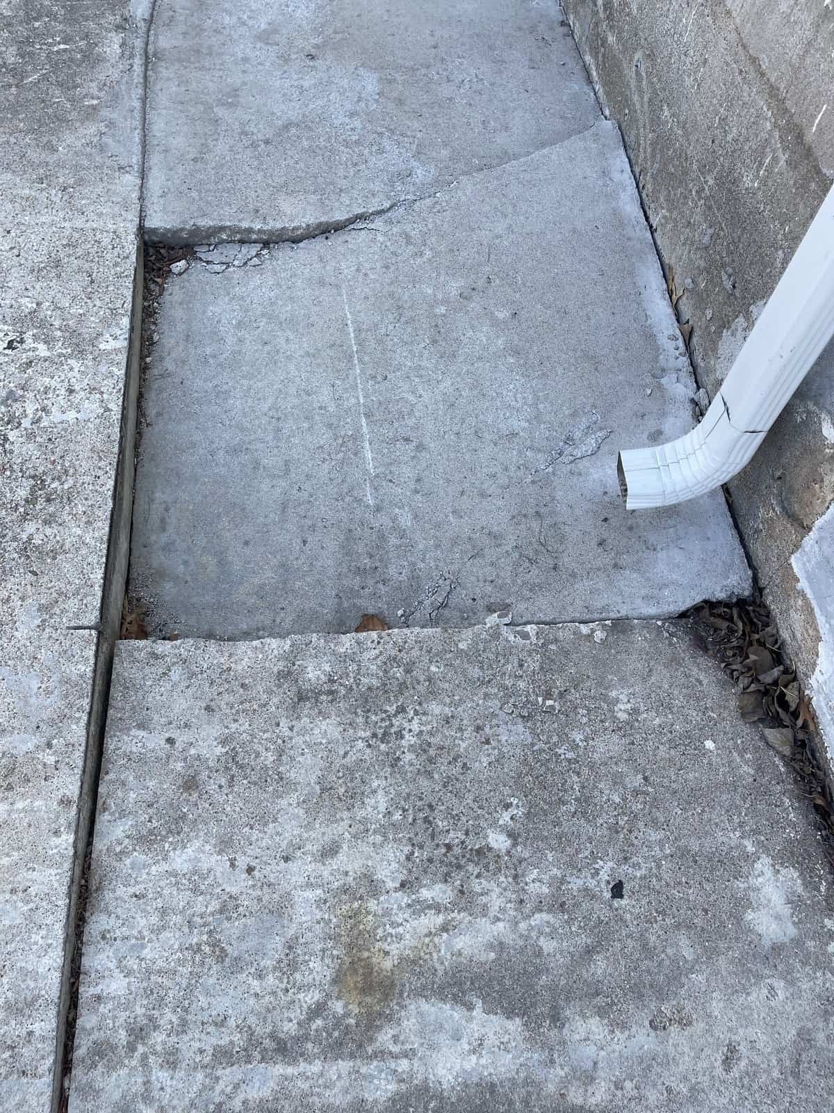 broken concrete from water damage from downspout